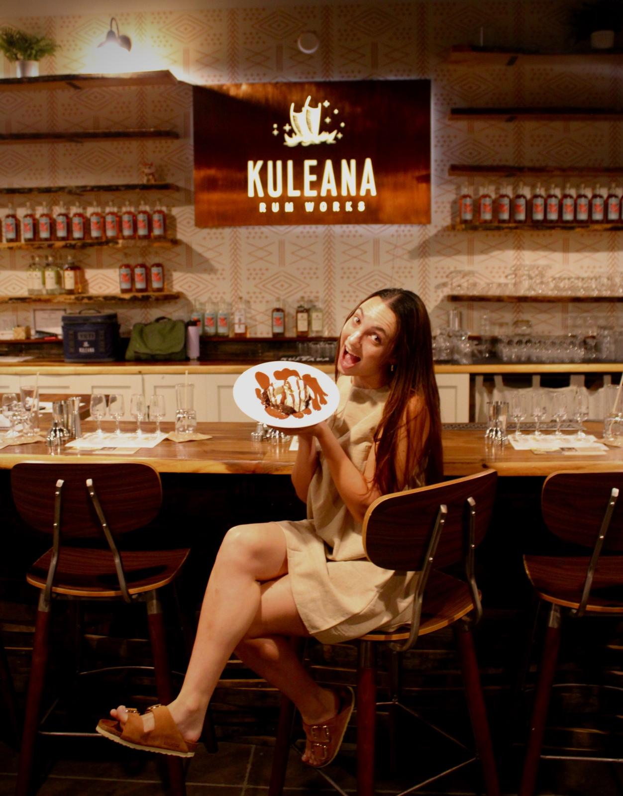 Model holding a plate at the bar at Kuleana Rum Works