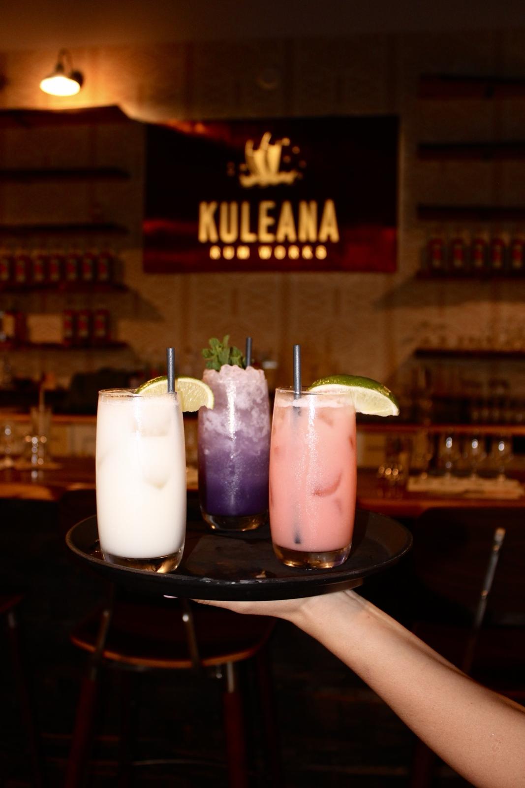 Three cocktails on a tray under the Kuleana Rum Works sign