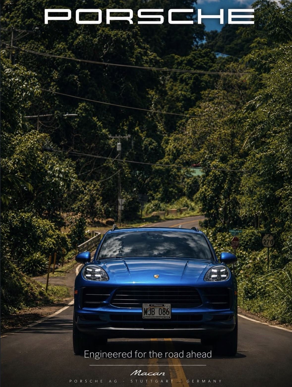 Blue Porsche Macan on a jungle road