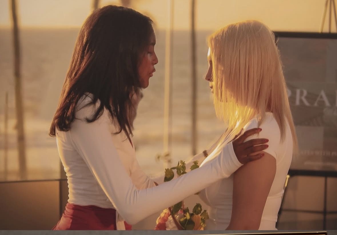 Two women embracing at sunset during a PRAISE Wellness Club event
